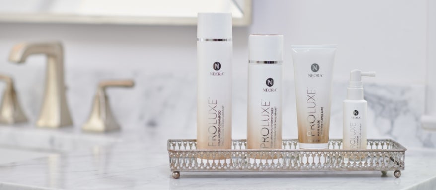 Image of the ProLuxe Hair Care System on a beaded tray on a bathroom countertop.