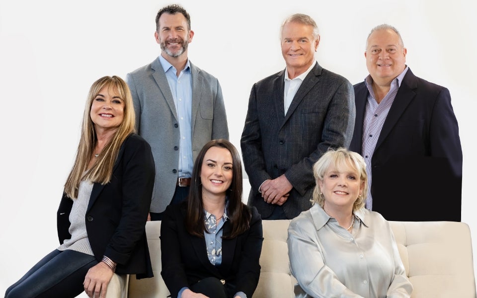 Group shot of Neora executives around a couch.