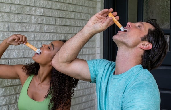 Lifestyle shot of a man and woman both taking NeoraFit™ Block + Balance Pre & Probiotic Powder.